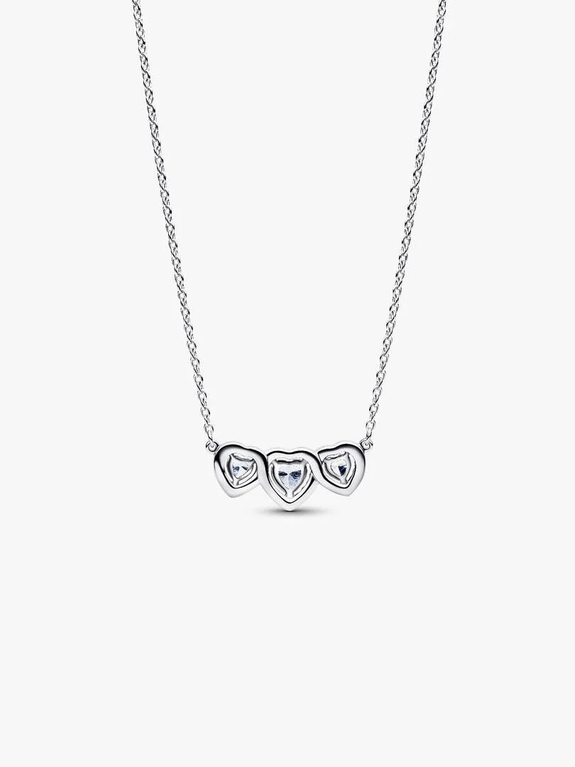 Silver necklace with three heart-shaped pendants on a white background