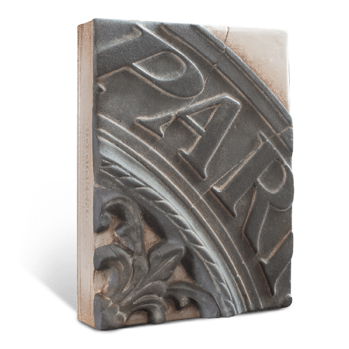 Decorative tile with embossed text "Paris" and floral design on a white background