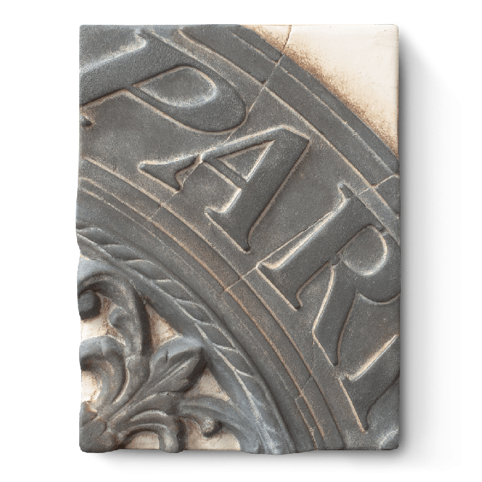 Decorative tile with embossed text "Paris" and floral design on a white background