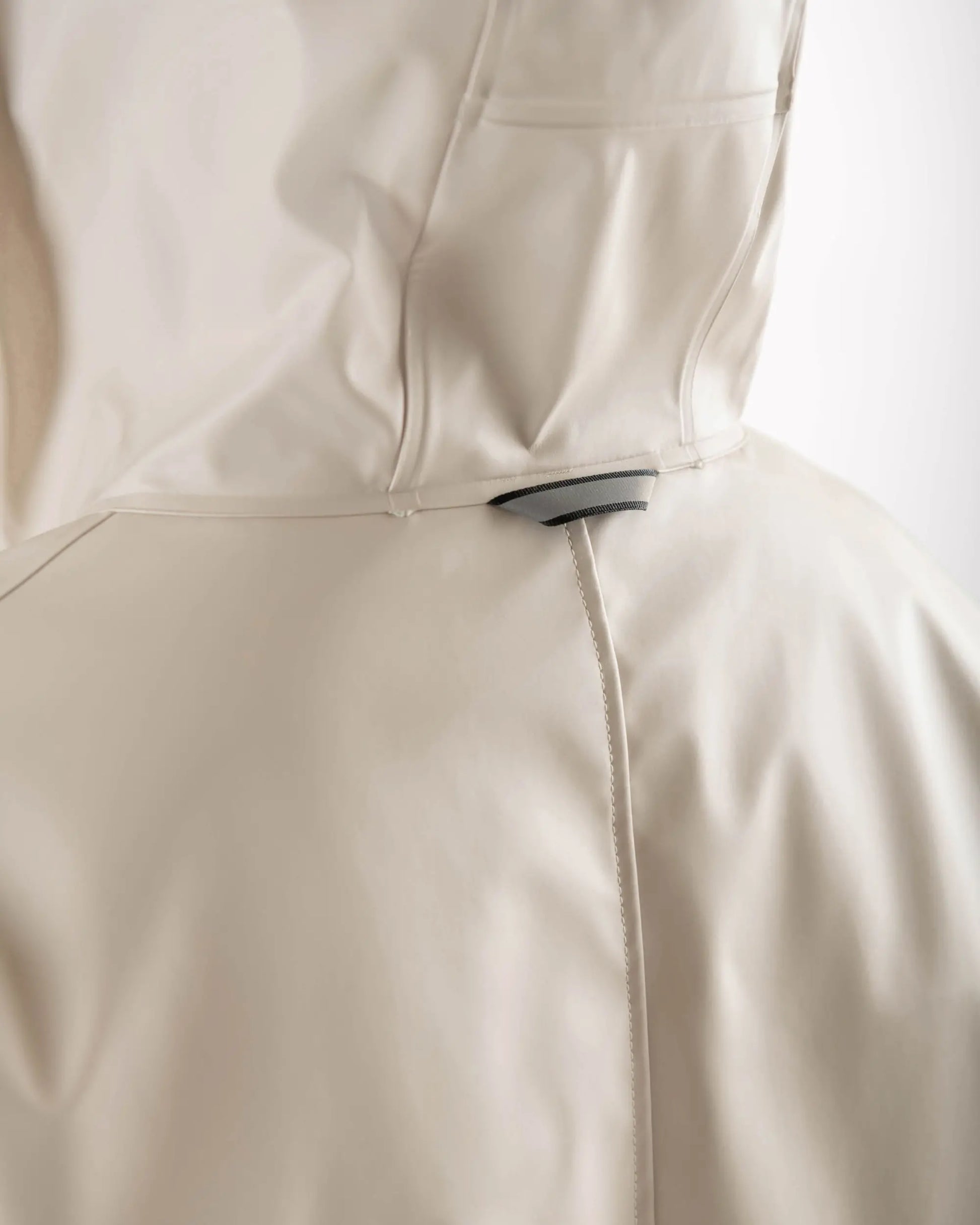 Close-up of a beige garment with a zipper on a white background
