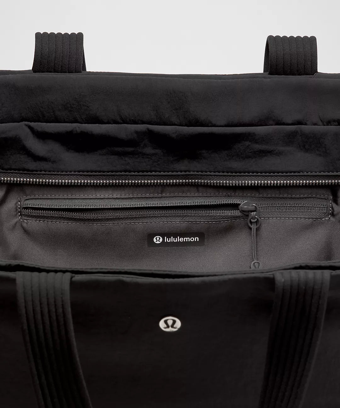 Black Lululemon bag with visible branding on a light gray background