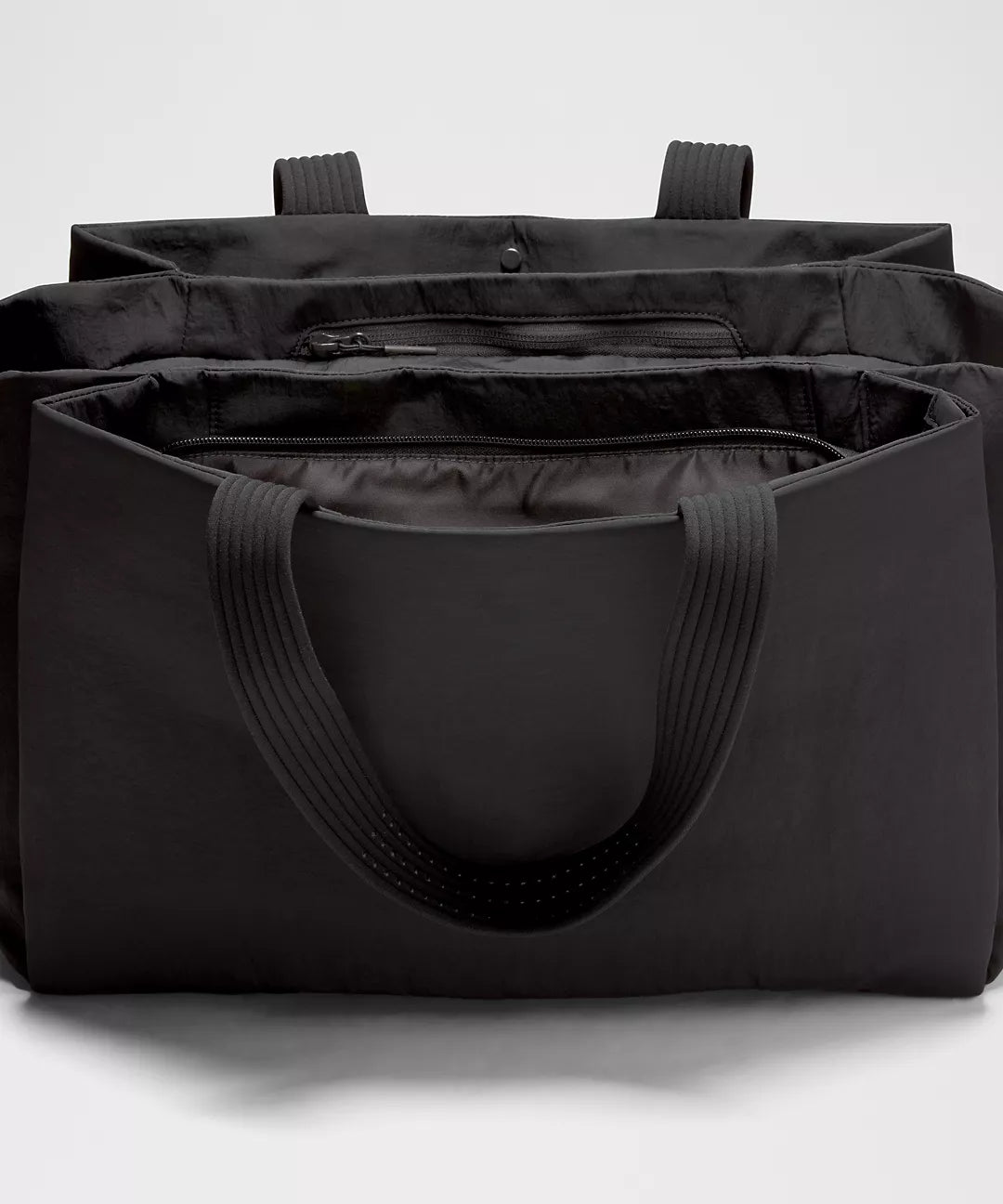 Black tote bag with multiple compartments on a white background