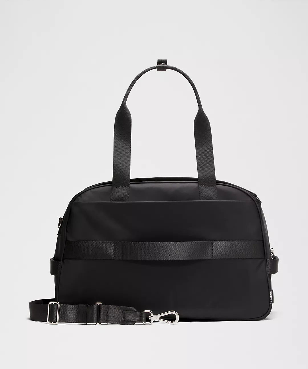 Black duffel bag with shoulder strap on a light gray background