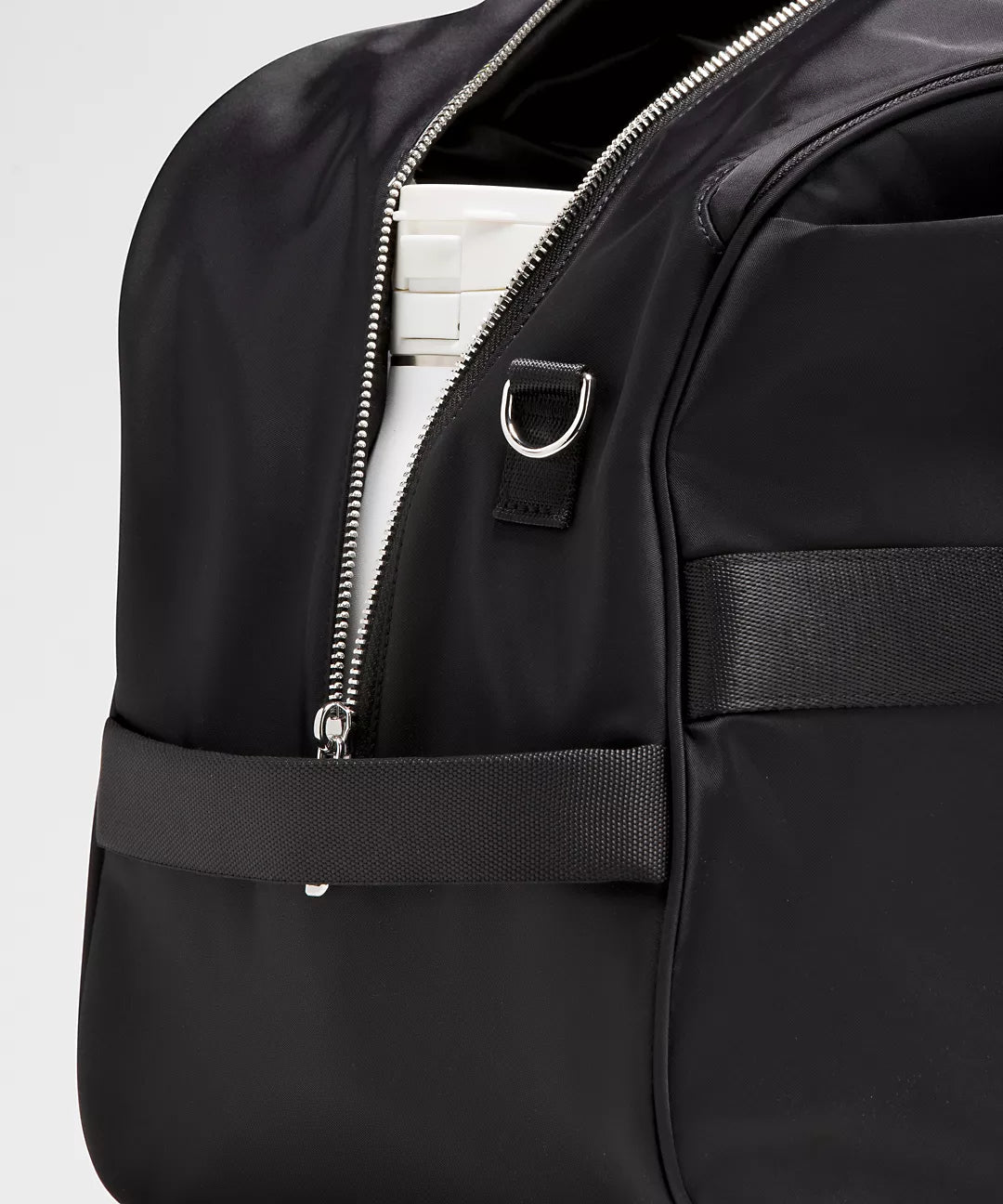 Black duffle bag with a visible zipper on a light gray background