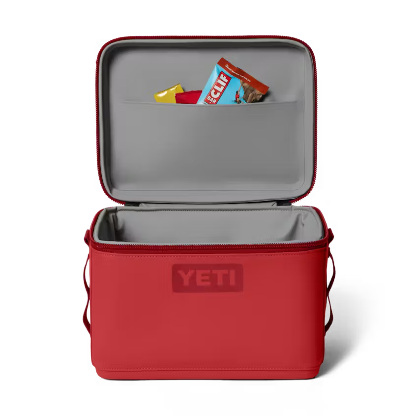 Red YETI cooler with open lid showing Clif bars on a white background
