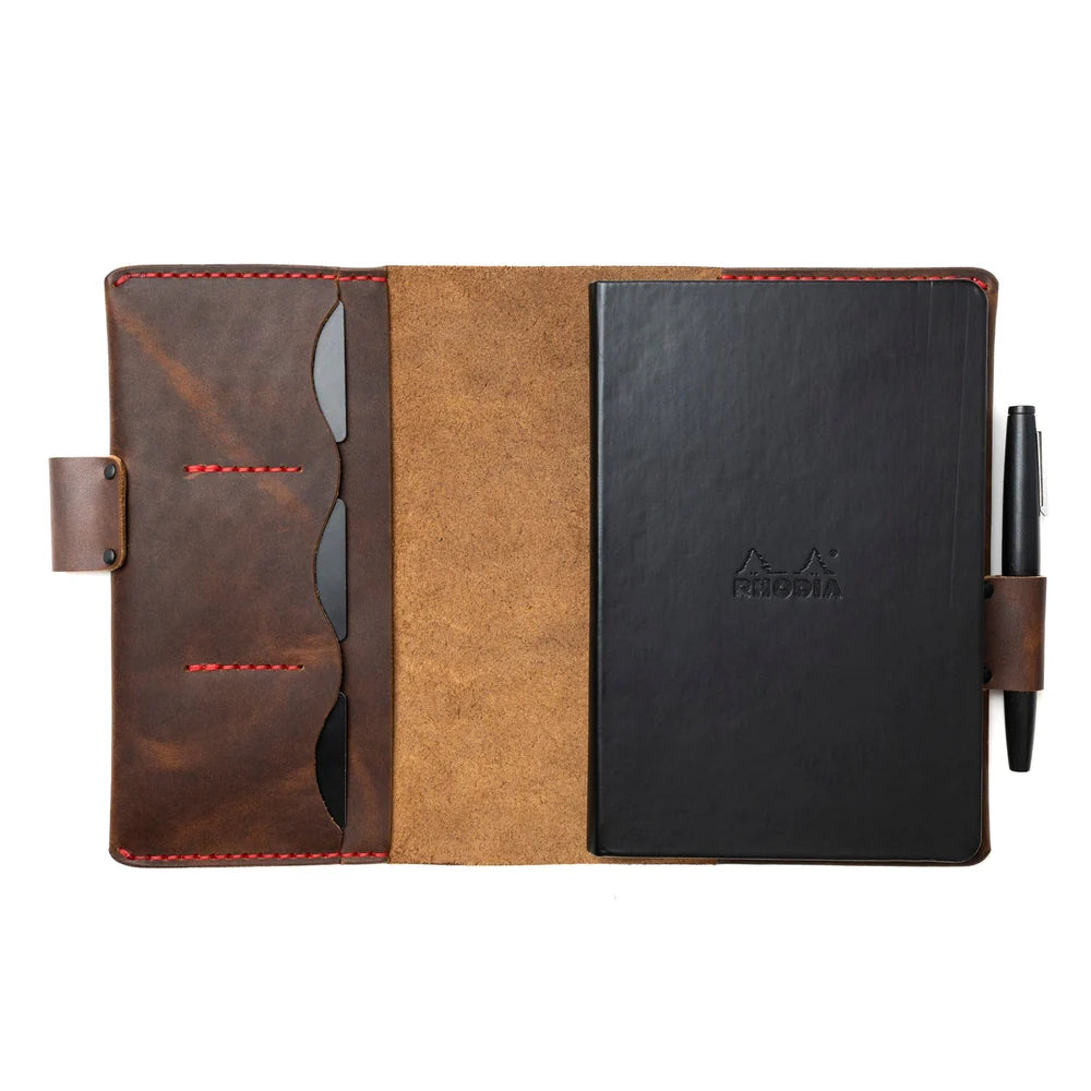 Leather-bound notebook with pen holder on a white background